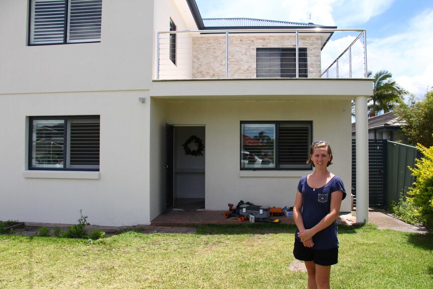 Natalie Hennessy stands in front of her home.