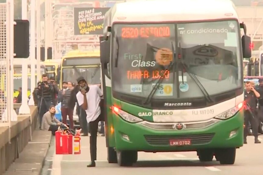 A man can be seen stepping off a bus.