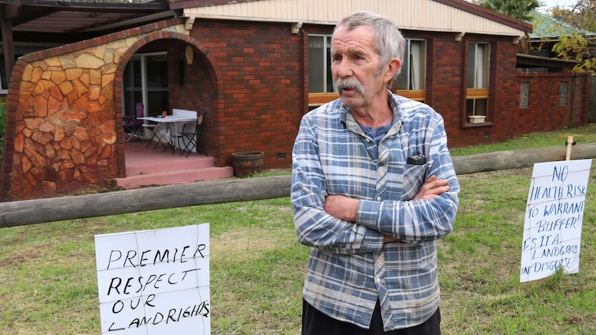Mandogalup resident Reid Donald outside his home with protest signs attached to his fence.