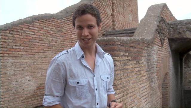 Man stands beside wall of Roman building