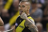 Dustin Martin clenches his fist and sticks his tongue out in celebration of a goal.