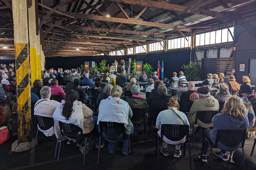 Seated Come Together For Yes attendees look towards a stage in Hobart's Goods Shed