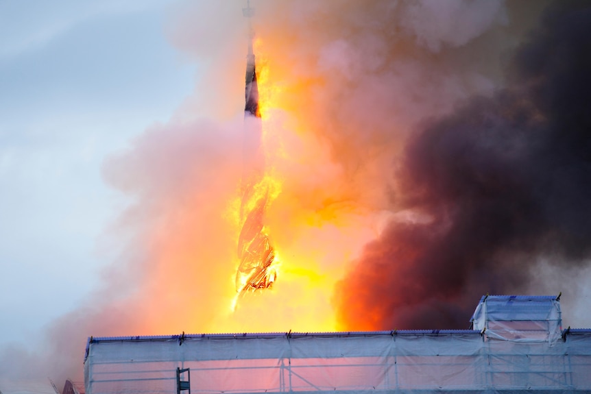 Fire and smoke rise out of the Old Stock Exchange's spire.