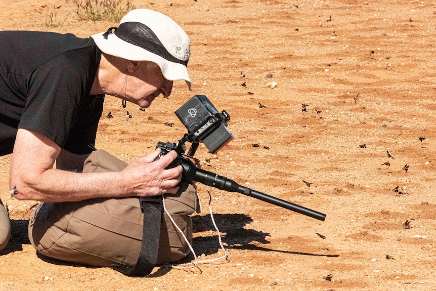 David Parer filming a burrowing bee with a long probe lens