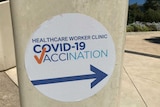 A sign at the Royal Adelaide Hospital points the way to a COVID-19 vaccination clinic.