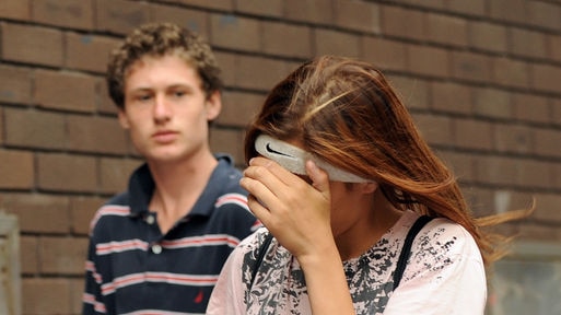 Cheyene Back (r) covers her face as she leaves the NSW District Court