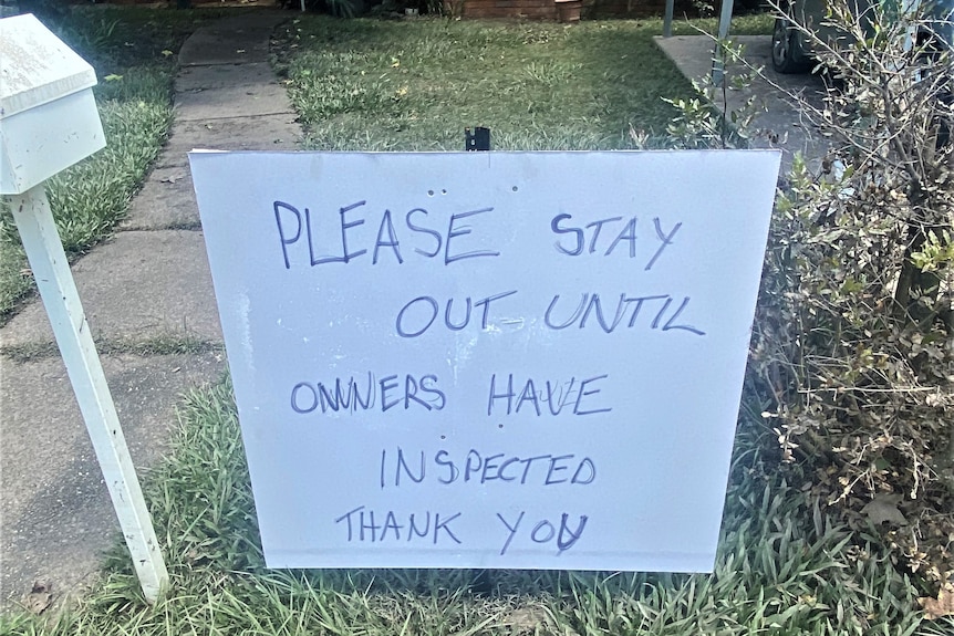 A sign reading "Please stay out until owners have inspected"