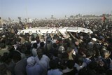 The hearse carrying Benazir Bhutto is mobbed in during the funeral procession.