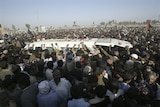The hearse carrying Benazir Bhutto is mobbed in during the funeral procession.