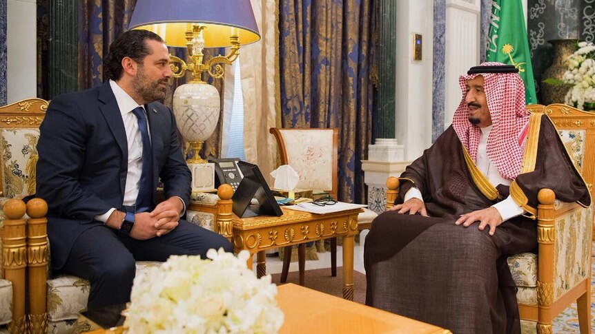 Saudi King Salman sits across from Lebanese PM Saad Hariri, both are smiling
