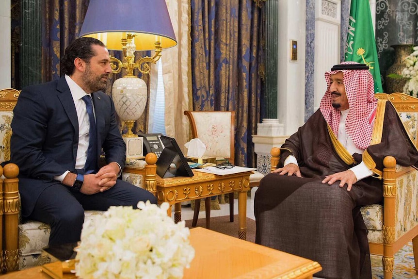 Saudi King Salman sits across from Lebanese PM Saad Hariri, both are smiling
