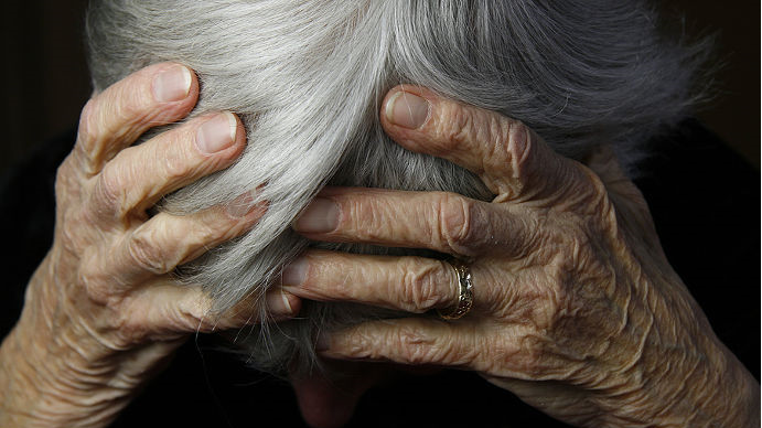 A woman holds her head in her hands