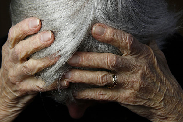 A woman holds her head in her hands