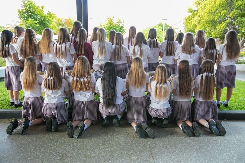 A class of year 12 girls prepare their hair for donation