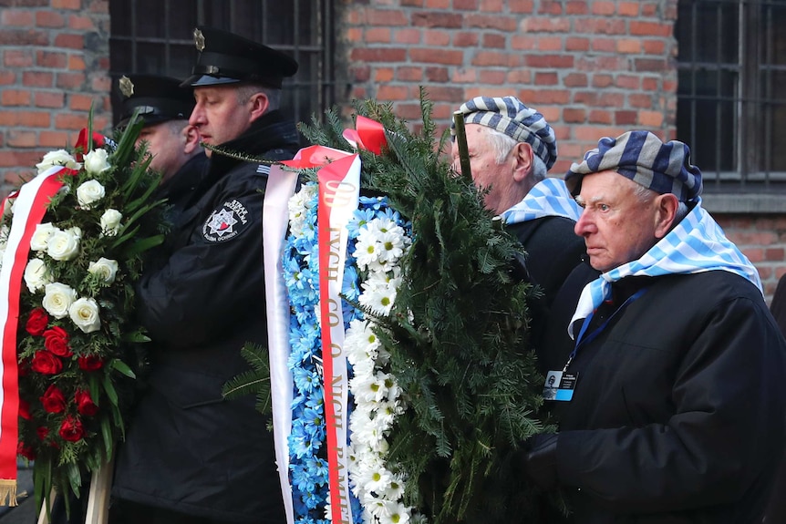 Survivors carry a wreath at the Auschwitz Nazi death camp.