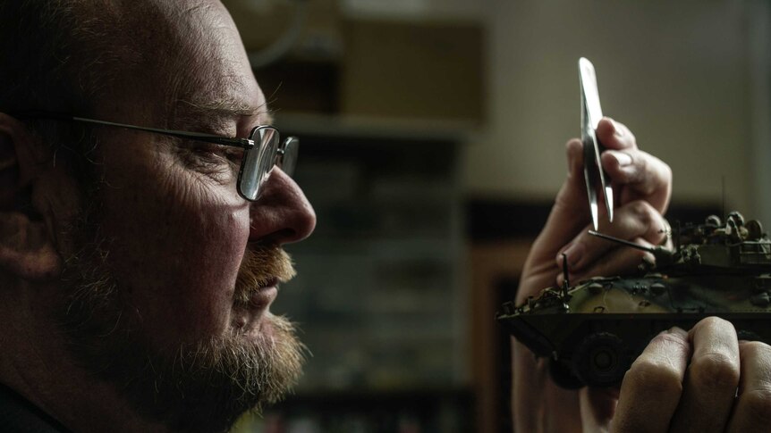 A man works on his model vehicle