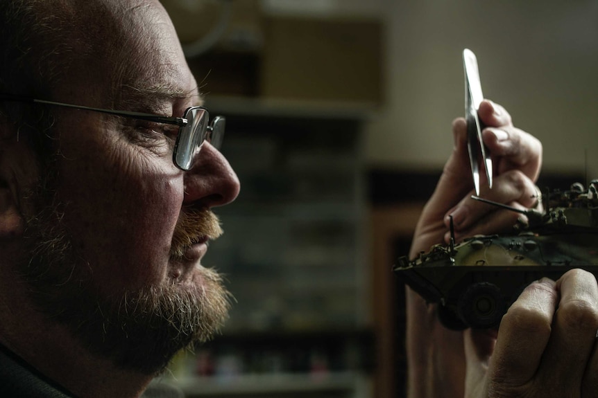 A man works on his model vehicle