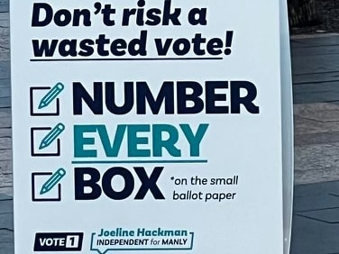 A sign which reads don't risk a wasted vote, number every box