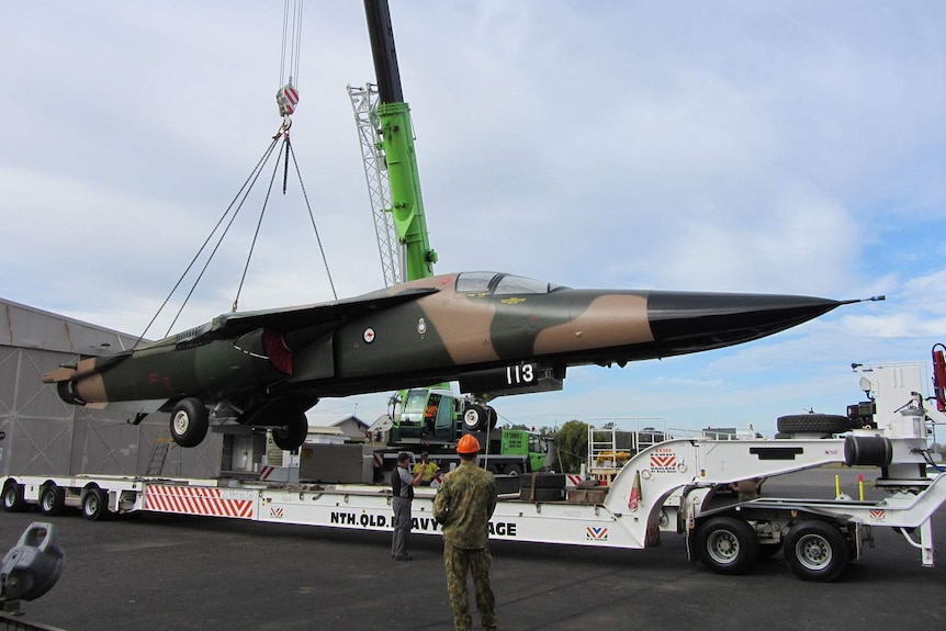 Retired F-111 jet gets loaded onto a truck at RAAF Base at Amberley, west of Brisbane in June 2013