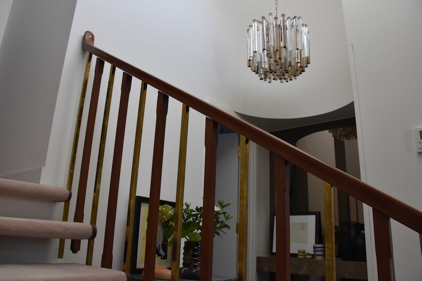 The interior of a house showing a staircase and chandelier.