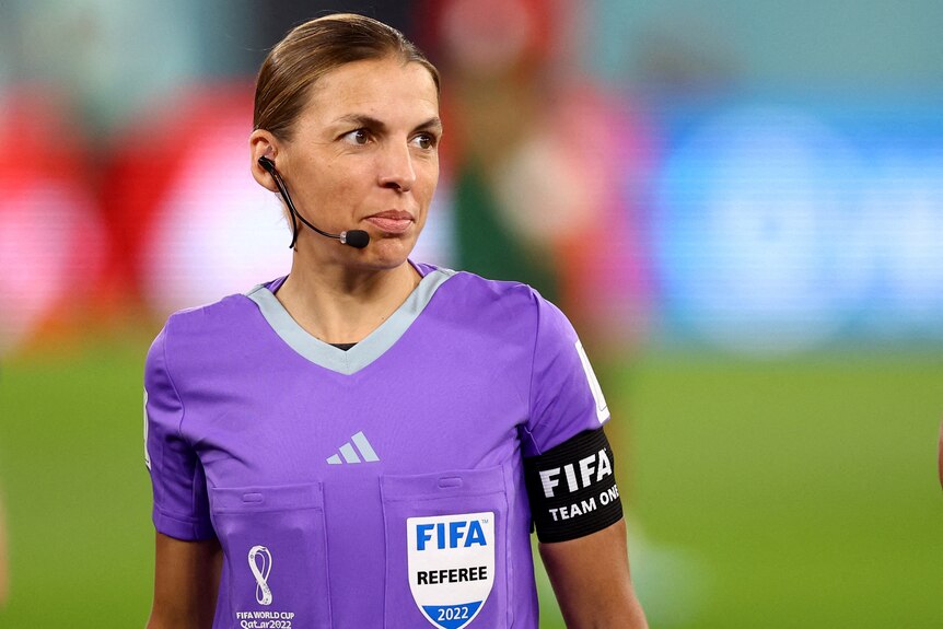 Stephanie Frappart wears a headset and blue referee's kit