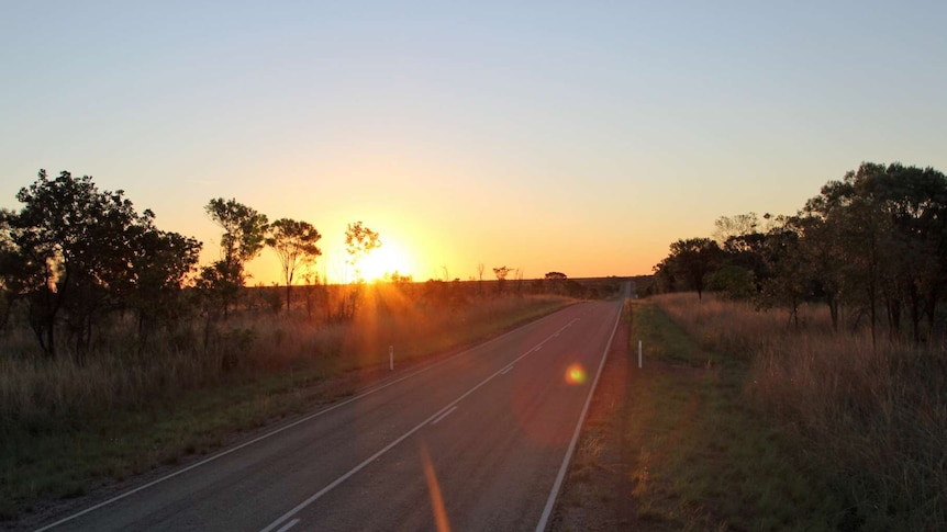 a sunset over a bitumen road