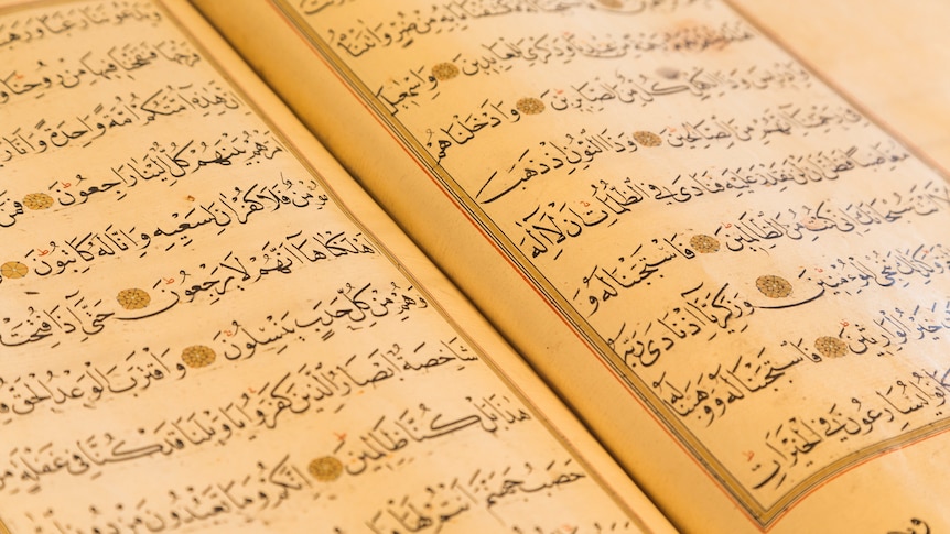 Close up of a page of the Qur'an. Arabic writing on a decorated page