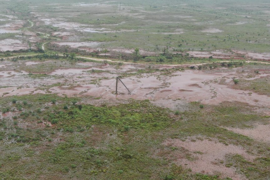 a flooded paddock with a power pole down