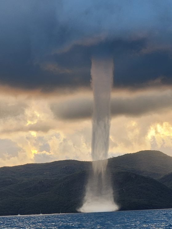 A waterspout forming near an island.