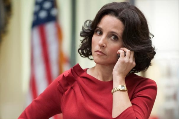 Julia Louis-Dreyfus, as Selina Meyer, in a room in the White House with an out-of-focus American flag behind her.