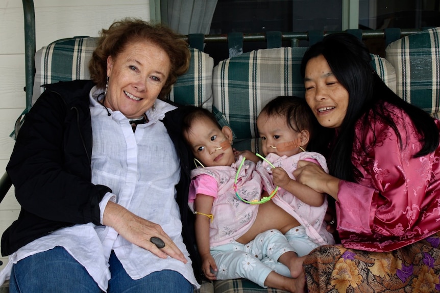 Gorman sitting on couch with twins between her and their mother.