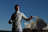 Edward Fernon poses with a fencing sword with the Opera House in the background..