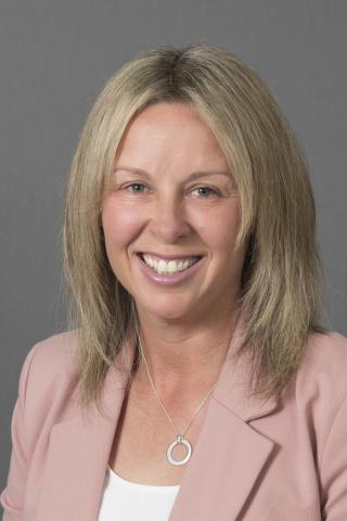 A blonde woman in a pink blazer 