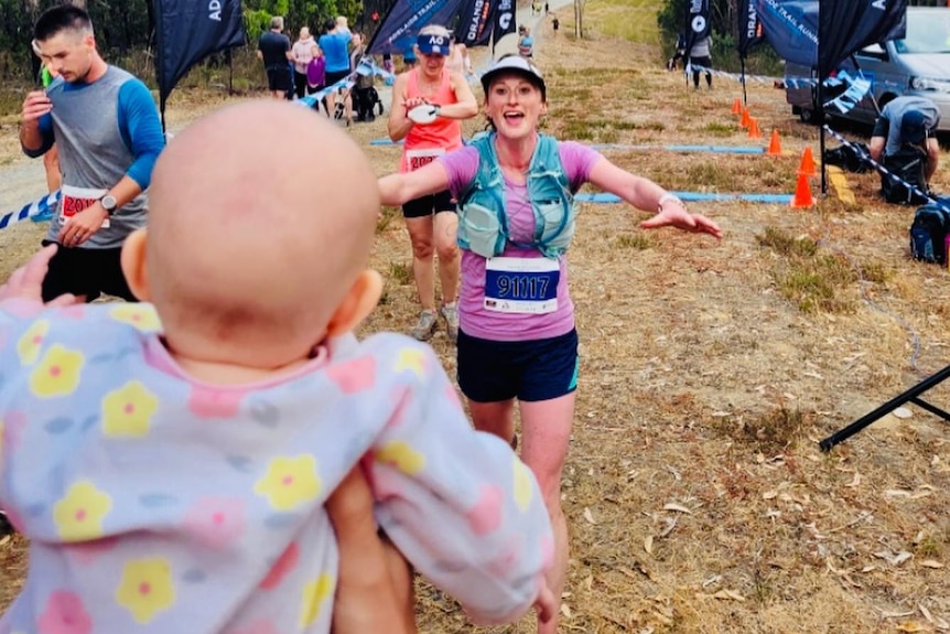 A woman runs across a finish line.