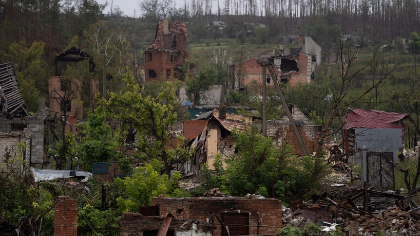 A side of a hill is covered with the debris of houses destroyed in a war
