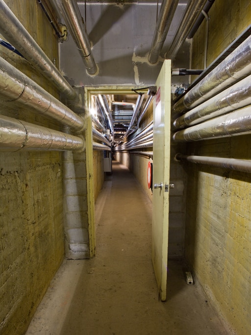 Pipes line the walls inside the service tunnel at ANU.