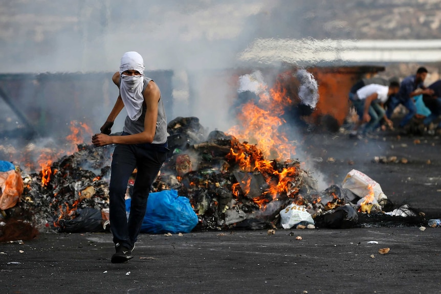 A Palestinian protester clashes with Israeli security forces