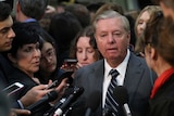 Senator Lindsey Graham surrounded by reporters.