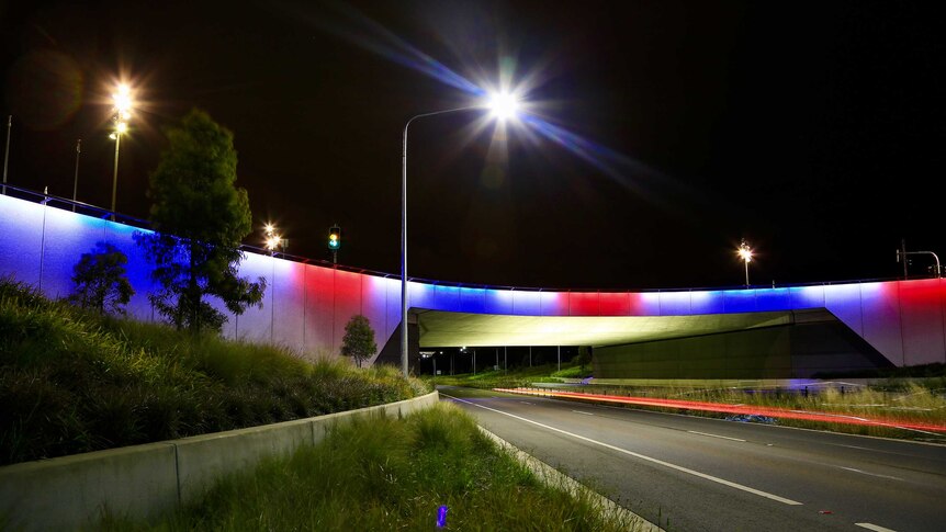 The Kings Avenue overpass on Parkes Way in Canberra lit up with blue, white and red lights following the Paris attacks.