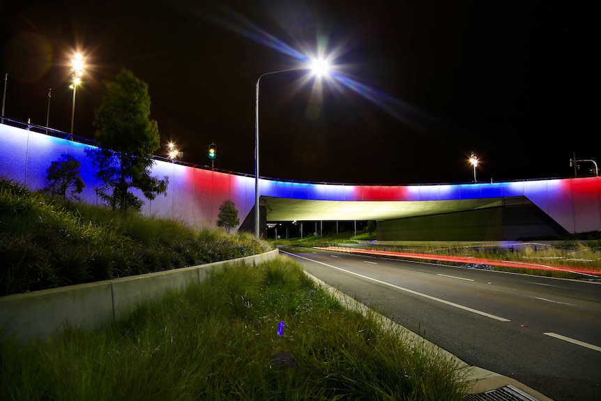 The Kings Avenue overpass on Parkes Way in Canberra lit up with blue, white and red lights following the Paris attacks.