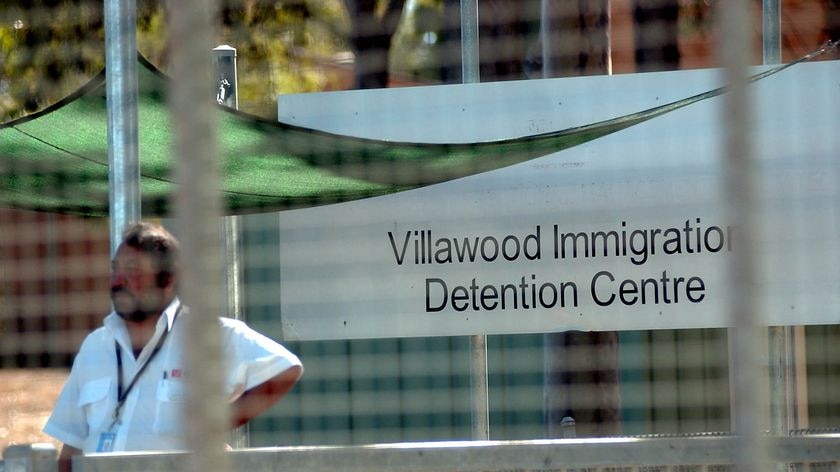 A security guard stands at the gate of the Villawood Detention Centre