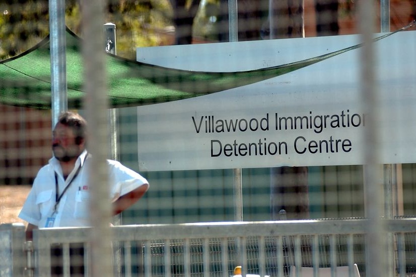 A security guard stands at the gate of the Villawood Detention Centre