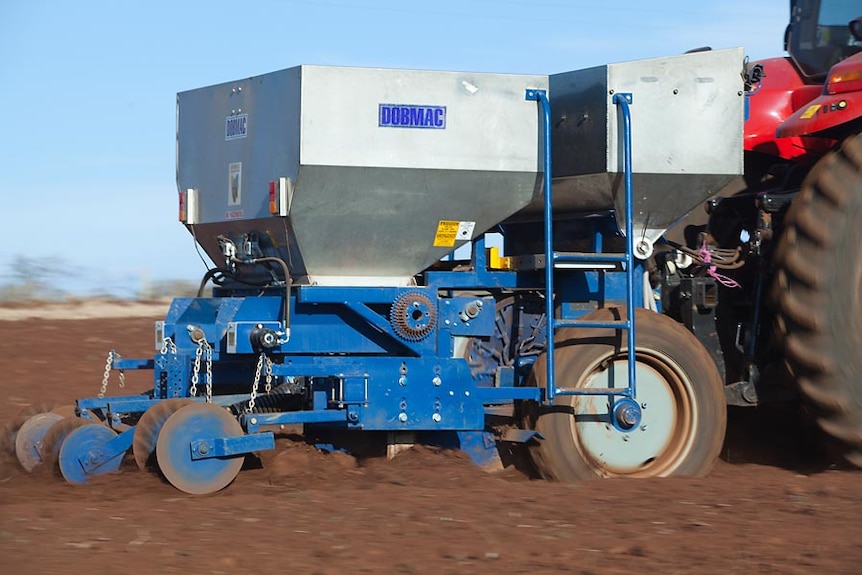 Close shot of a potato planter in action in north-west Tasmanian red volcanic soil.