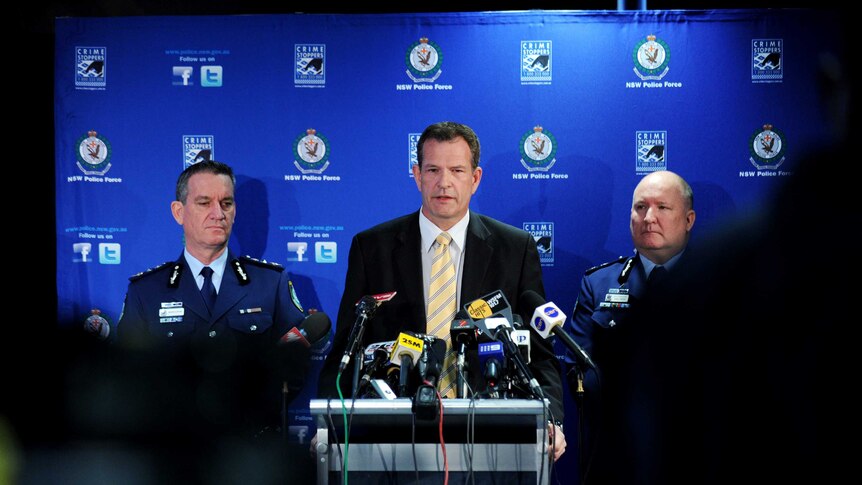 Three policeman giving a press conference.