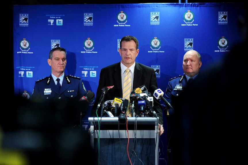 Three policeman giving a press conference.