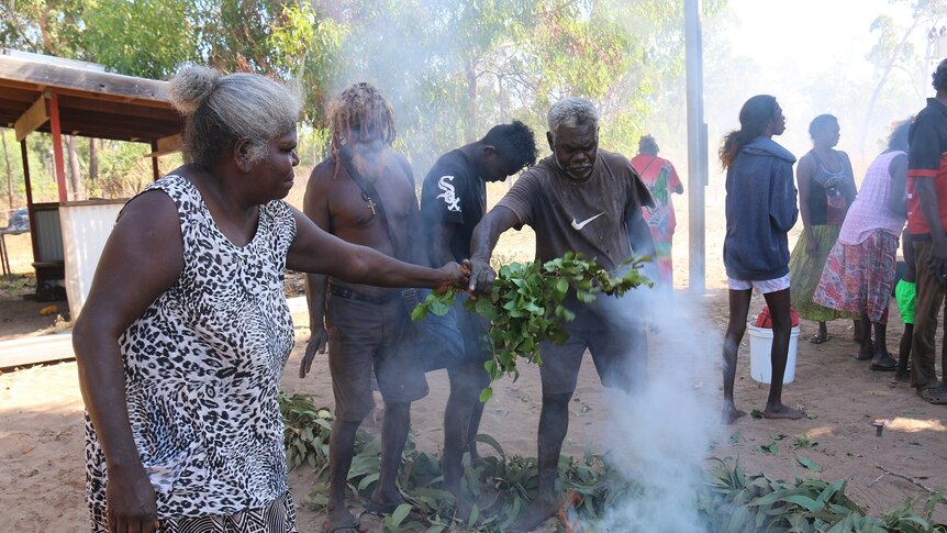 Helen Nyomba Gandangu (L) during a cleansing ceremony at burial site.