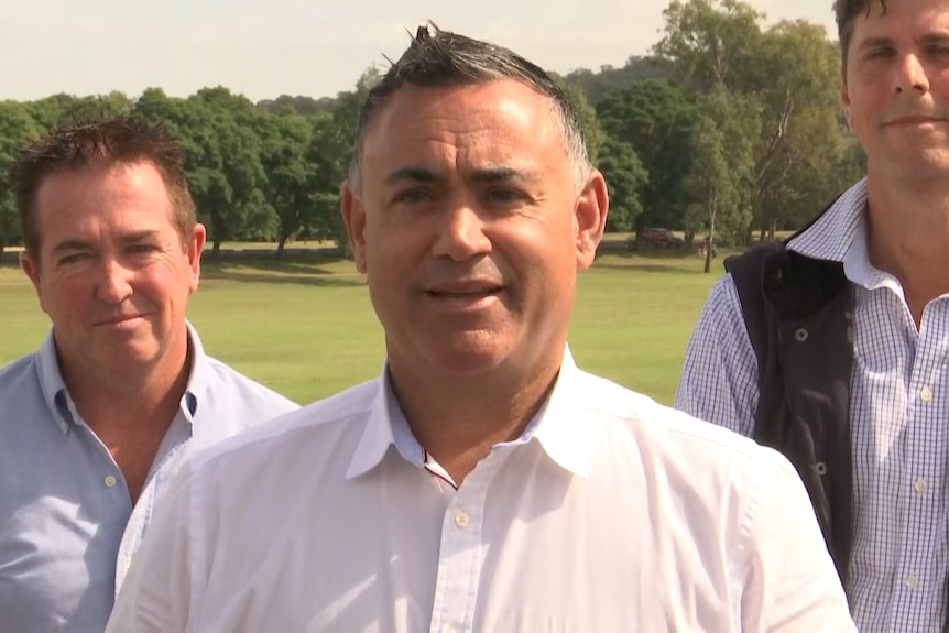 Three male politicians outdoors at a press conference