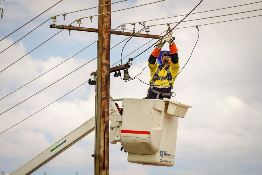A worker fixes powerlines