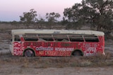 An old bus covered in slogans 'our river our life humanity forst' and 'Government mismanagement, not drought greed'.