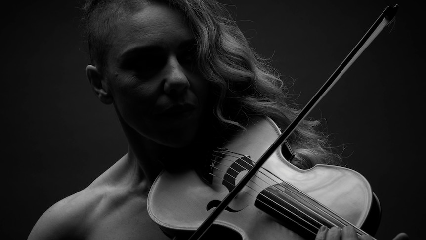 A black and white image of Veronique playing violin. She has her eyes closed and looks focussed.
